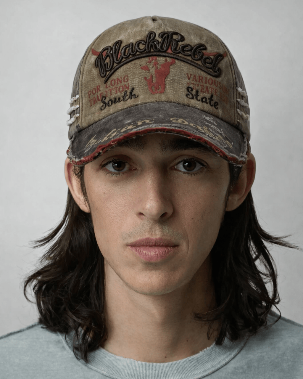 Rynor Black Rebel Cap – distressed camo and brown trucker hat with Black Rebel embroidery, worn by a model