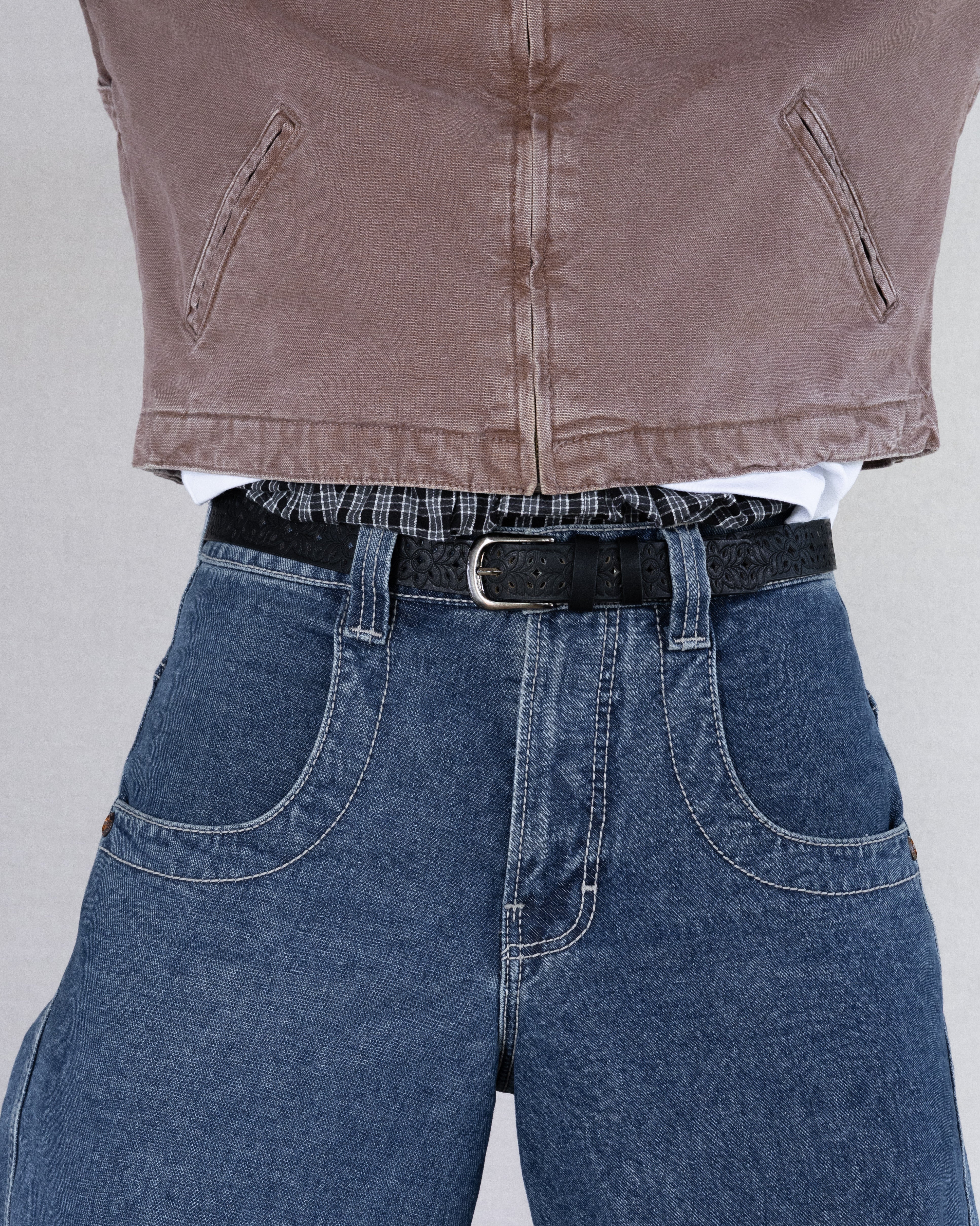 Rynor Carved Floral Belt – black belt with cutout-style tooling and metal buckle, worn by a model