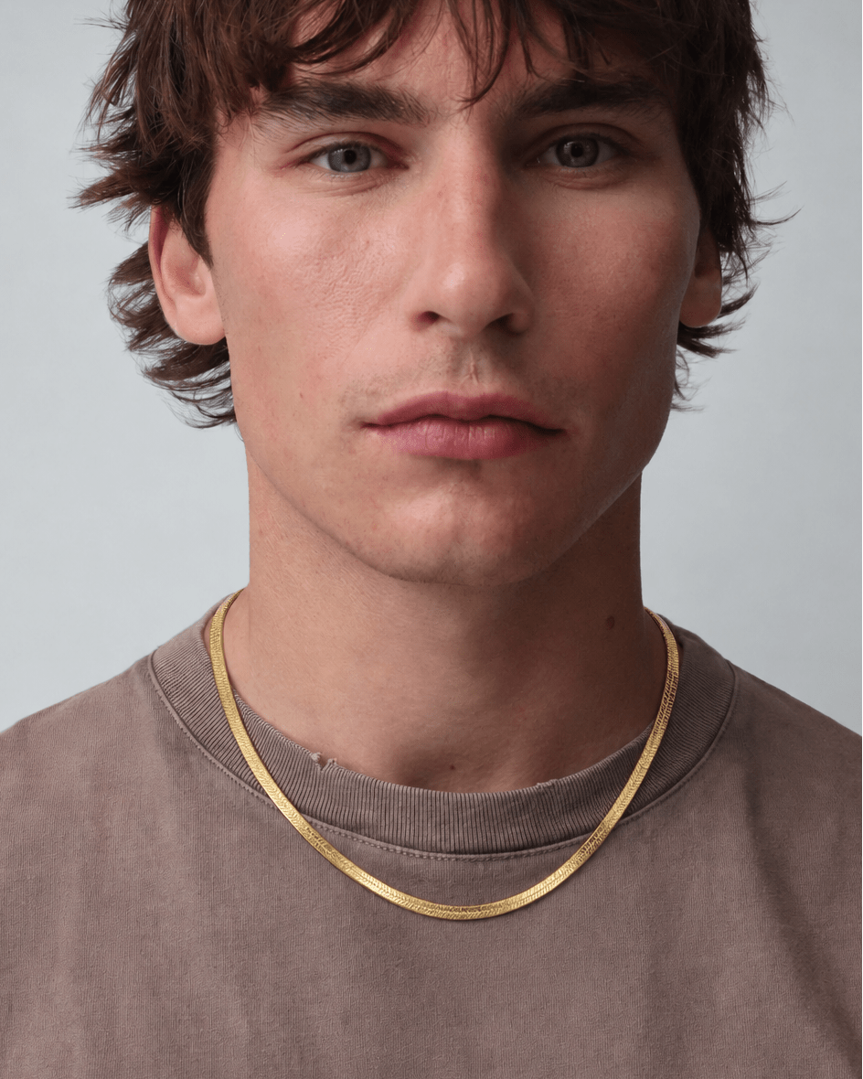 Rynor Gold Herringbone Necklace – gold-tone flat herringbone chain necklace, worn by a model