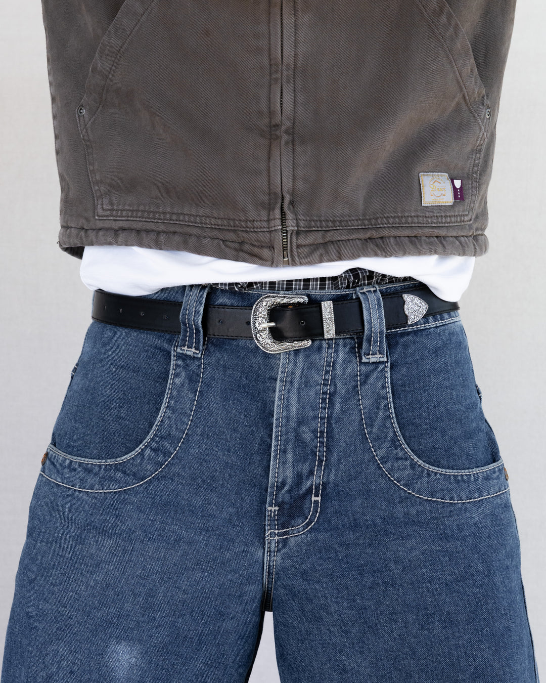 Rynor Iron Scroll Belt – black belt with engraved scrollwork buckle, worn by a model