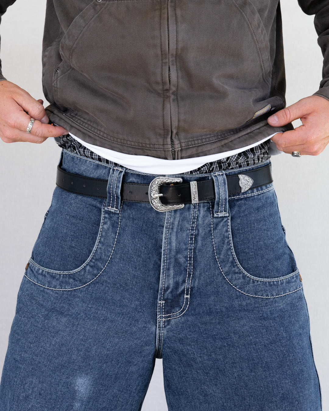Rynor Iron Scroll Belt – black belt with engraved scrollwork buckle, worn by a model