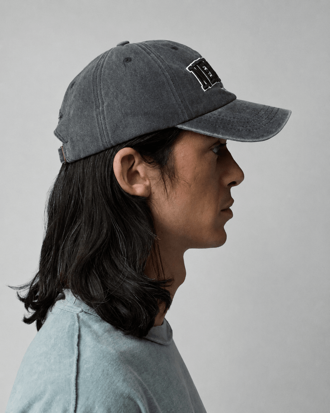 Rynor New York Cap – washed black baseball cap with New York embroidery, worn by a model