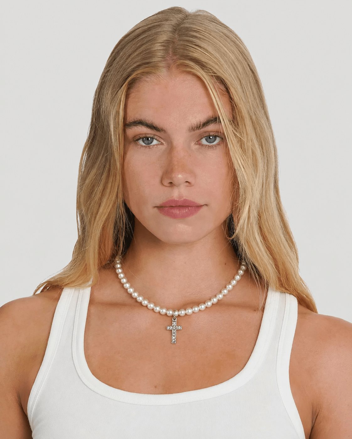 Rynor Pearl Cross Necklace – white pearl bead necklace with cross charm, worn by a model