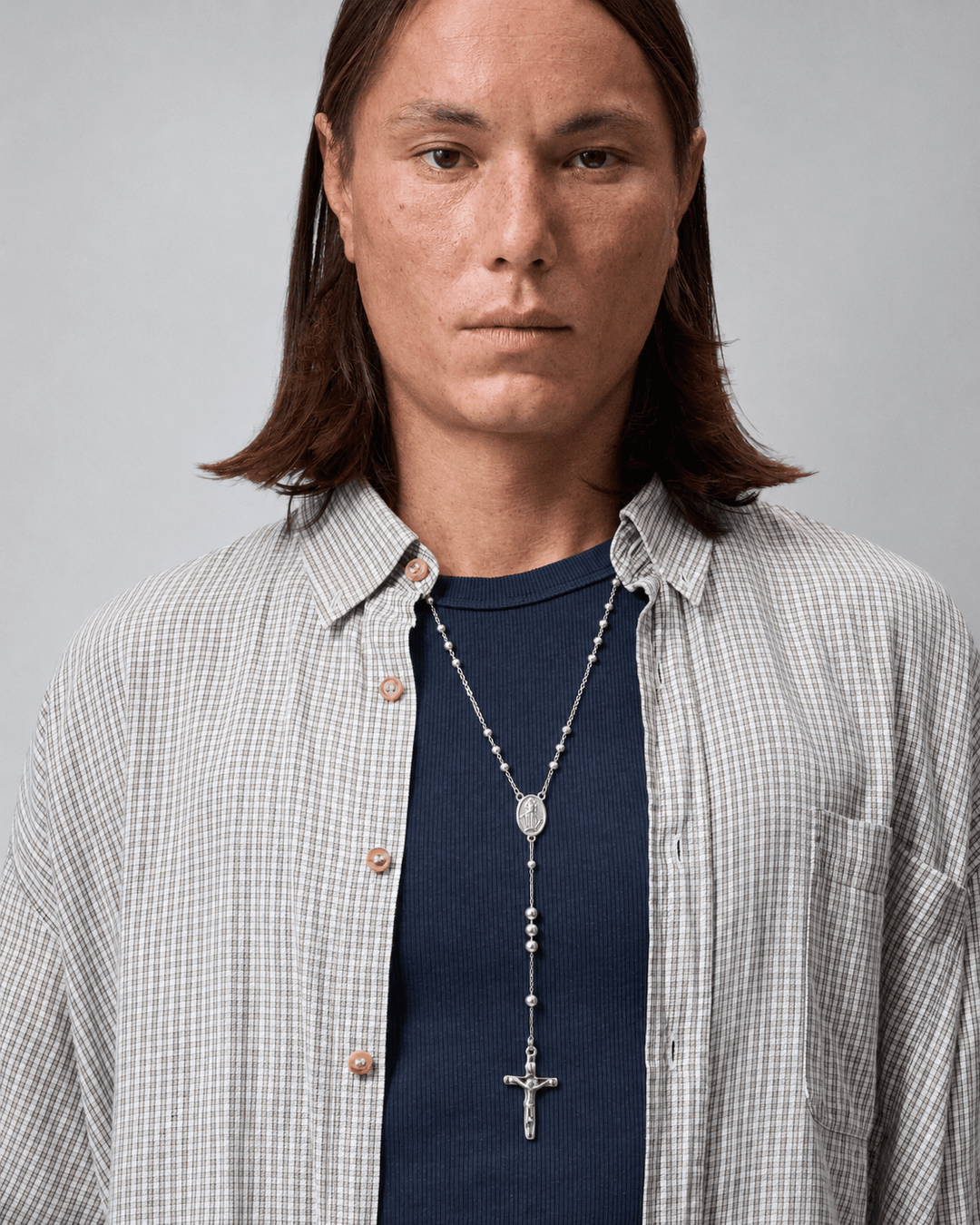 Rynor Rosary Drop Necklace – silver rosary-style bead chain necklace with cross pendant, worn by a model