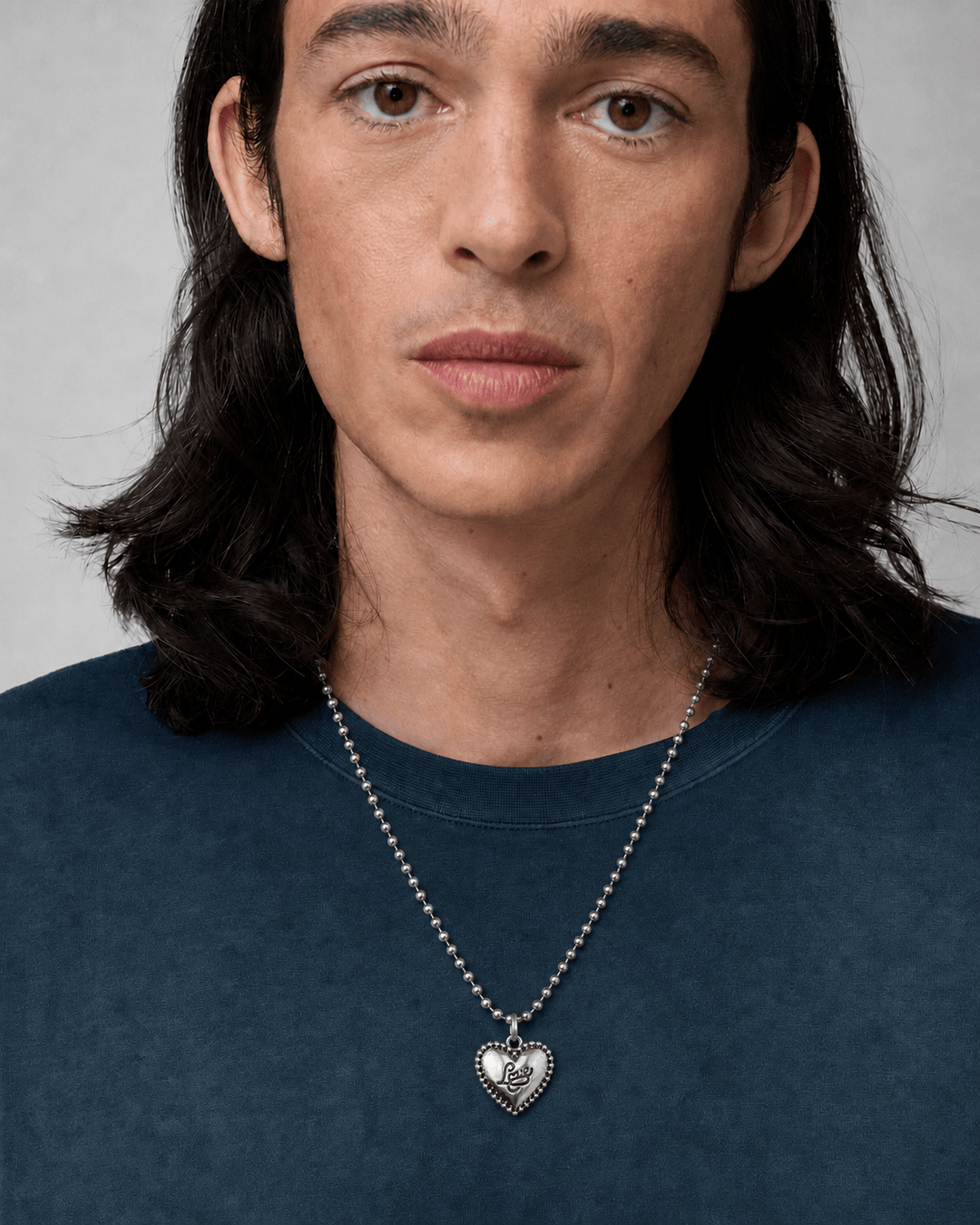 Rynor Script Heart Necklace – silver heart pendant necklace with script detailing, worn by a model