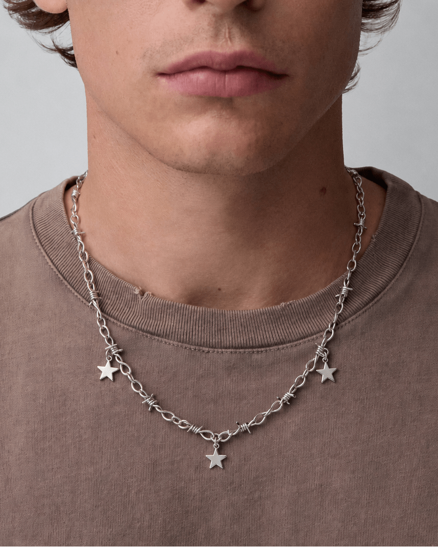 Rynor Star Charm Barbed Necklace – silver barbed wire chain necklace with hanging star charms, worn by a model