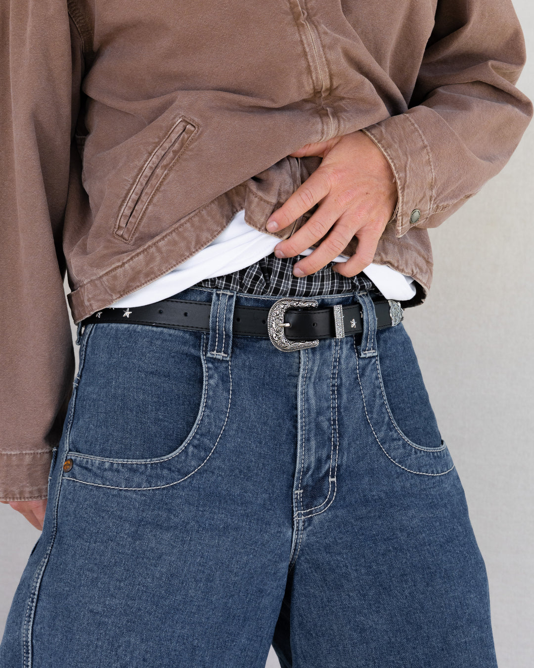 Rynor Starlight Western Buckle Belt – black belt with star studs and engraved western buckle, worn by a model
