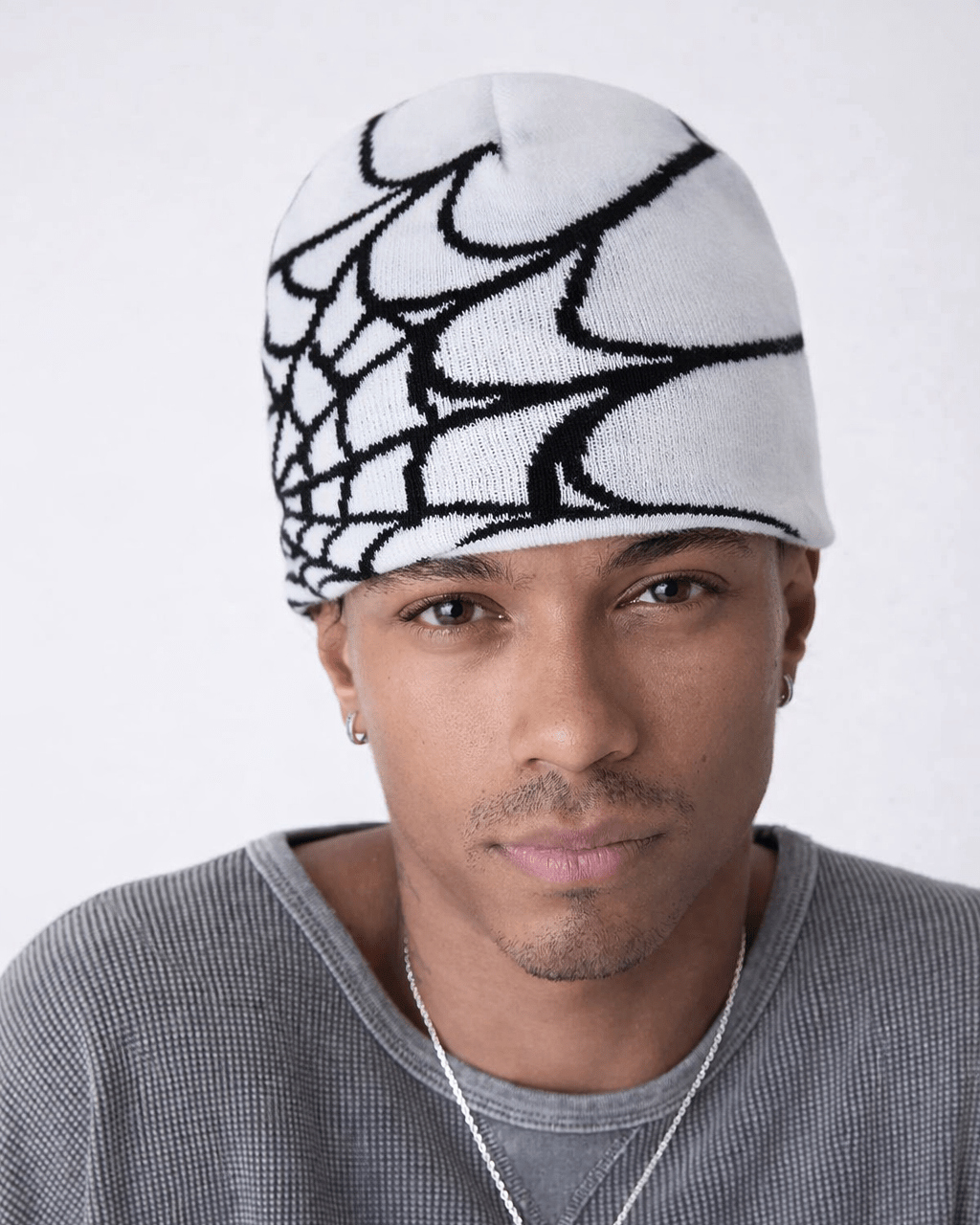 Rynor Web Knit Beanie – white and black spider web pattern knit beanie, worn by a model